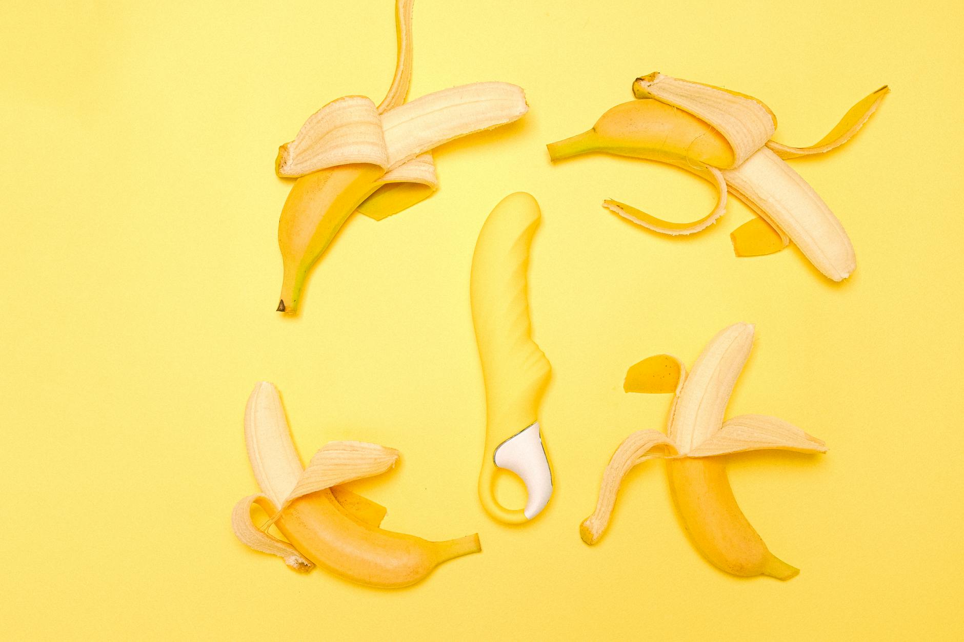 Yellow silicone lemon vibrator on a yellow background with fresh lemons