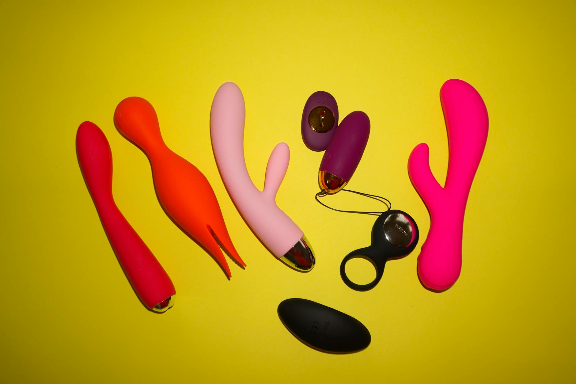 Woman holding colorful silicone vibrators, exploring options for postpartum pleasure
